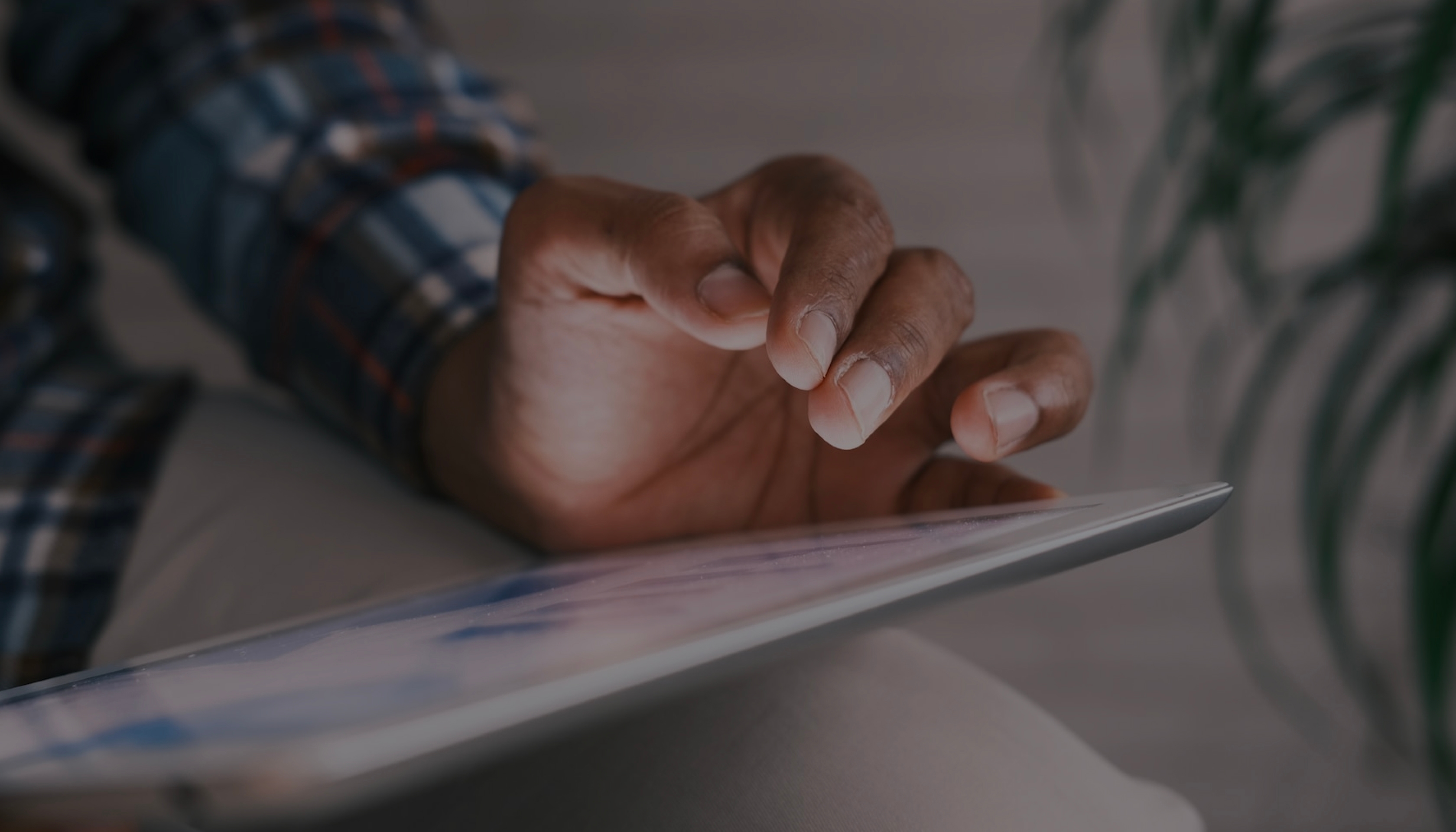 A soft focus photo of a woman in an office looking at a tablet device